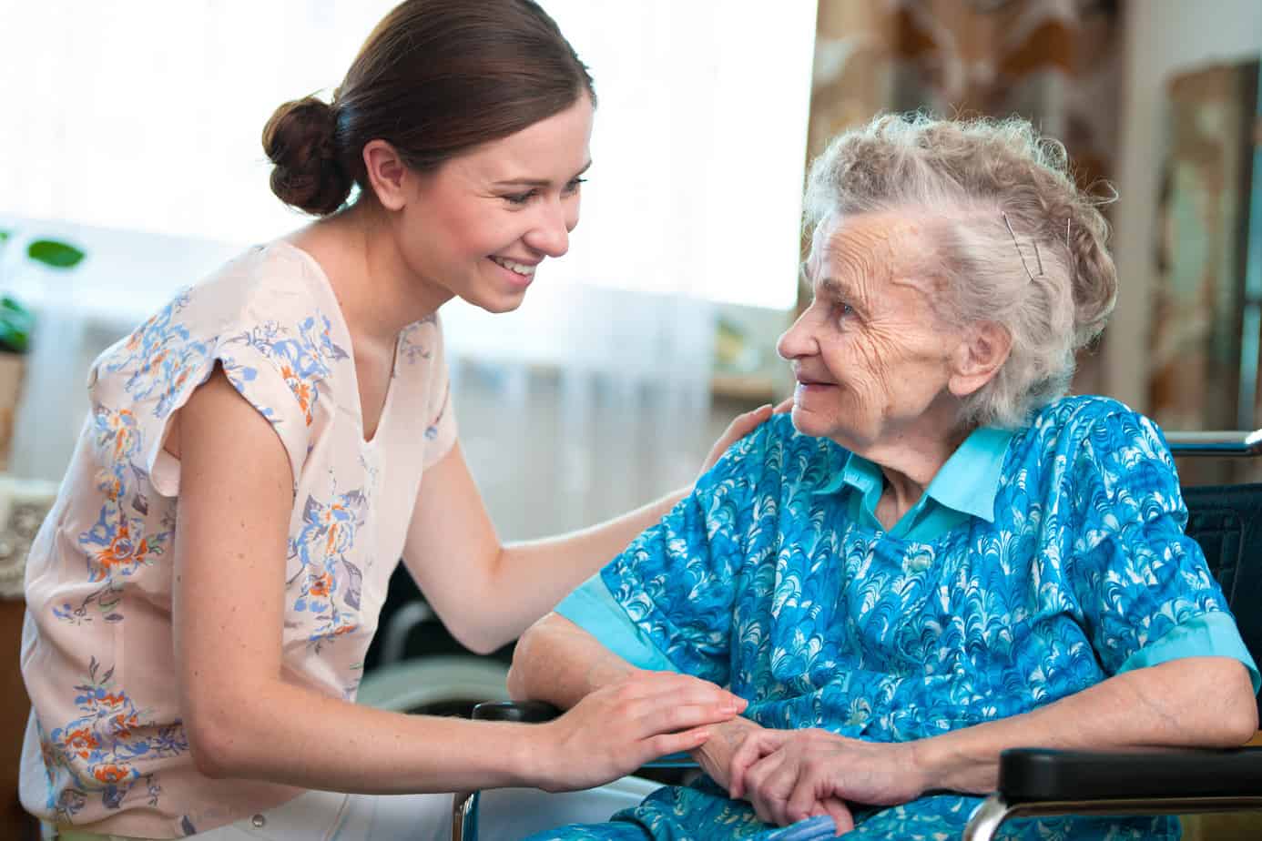 Compassionate elder care by a friendly caregiver with a senior woman in a wheelchair.